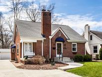 Charming brick home featuring a classic design, a welcoming porch swing, and well-maintained landscaping at 2615 Kessler Blvd E Dr, Indianapolis, IN 46220