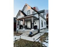 Charming two-story home featuring a covered front porch with black and white trim at 318 Congress Ave, Indianapolis, IN 46208