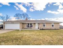 Charming single story home with stone facade, attached garage, and a well-maintained lawn at 323 Norris Dr, Anderson, IN 46013