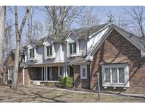 Charming two-story brick home featuring dormer windows and a covered front porch at 5214 Woodfield Dr, Carmel, IN 46033