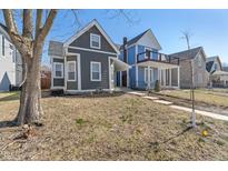 Charming gray two-story home with manicured lawn and inviting curb appeal on a sunny day at 569 N Tacoma Ave, Indianapolis, IN 46201