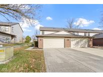 Attached two-car garage with brick facade and concrete driveway and small green lawn to the side at 6454 Bay Harbor Ln, Indianapolis, IN 46254