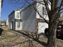 White two-story house featuring a brick-accented garage and mature trees in a sunny, residential neighborhood at 6647 Black Antler Cir, Indianapolis, IN 46217