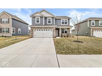 Charming two-story home with blue siding, brick accents, a two-car garage, and a well-manicured front lawn at 6713 Cardiff Dr, McCordsville, IN 46055