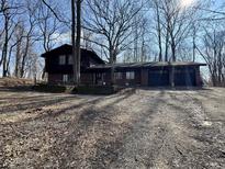 Two-story brick home with a three-car garage in a wooded lot at 8985 Huggin Hollow Rd, Martinsville, IN 46151