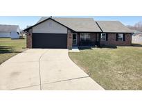 Charming single-story brick home with a well-maintained lawn and a long concrete driveway at 1208 Western Ct, Shelbyville, IN 46176