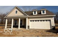 Charming single-story home featuring a two-car garage, covered porch, and light beige siding, nestled on a treed lot at 14383 Coyote Ridge Dr, Noblesville, IN 46060