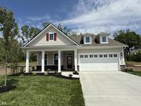 Charming single-Gathering home with manicured lawn, red door, and white garage doors under a sunny blue sky at 14383 Coyote Ridge Dr, Noblesville, IN 46060