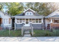 Charming single-story home featuring a welcoming porch and fenced front yard at 2433 Indianapolis Ave, Indianapolis, IN 46208