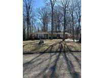 Charming single-story brick home with white shutters surrounded by mature trees at 28 Cambridge Ct, Anderson, IN 46012