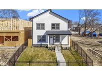 Charming two-story home with black fencing, lush lawn, and welcoming front porch at 35 N Keystone Ave, Indianapolis, IN 46201