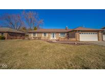 Charming brick ranch-style home with attached garage, complemented by a well-maintained lawn and blue sky at 3530 N County Road 950 E, Brownsburg, IN 46112