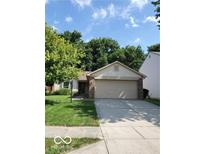 Charming single-story home with a two-car garage, lush green lawn, and a well-manicured landscape at 5822 Blackley Ln, Indianapolis, IN 46254