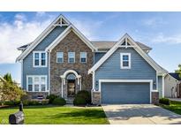 Charming two-story home with a brick facade, blue siding, and well-manicured lawn at 664 Hythe Way, Westfield, IN 46074