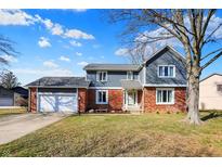 Charming two-story home boasts a brick and siding exterior with an attached two car garage at 7929 Castle Lake Rd, Indianapolis, IN 46256