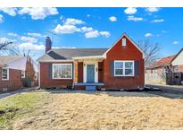 Charming red brick home featuring a blue front door and lovely landscaping at 910 N Downey Ave, Indianapolis, IN 46219