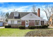 Charming single-Gathering home featuring a brick facade, dormer window, and well-manicured landscaping at 1149 E 56Th St, Indianapolis, IN 46220