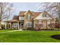 Charming two-story home with stone accents, covered porch, and well-manicured lawn at 11686 Belle Plaine Blvd, Fishers, IN 46037