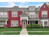 Charming townhome with red brick facade, manicured lawn, and inviting entrance at 1215 Middlebury Dr, Westfield, IN 46074