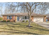 Charming single-story brick home with manicured lawn, attached garage, and inviting curb appeal at 1234 W 81St St, Indianapolis, IN 46260