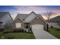 Charming brick home featuring an attached two-car garage, manicured lawn and attractive landscaping at 12610 Broadmoor N Ct, Fishers, IN 46037