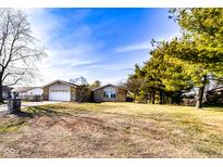 Charming single-story home with a well-manicured lawn and mature trees in a tranquil neighborhood setting at 12930 River Grove Dr, Columbus, IN 47203