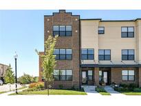 Modern brick and beige townhouse with black-trimmed windows under a clear blue sky at 12974 Pettigru Dr, Carmel, IN 46032