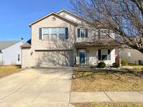Charming two-story home features a brick facade, attached garage and covered porch entrance at 14243 Holly Berry Cir, Fishers, IN 46038