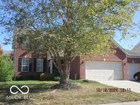 Charming brick home with a two-car garage and mature trees in the front yard at 1429 Lavender Ln, Greenwood, IN 46143