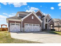 Charming two-story home with brick and stone accents and a spacious three-car garage at 14347 Camelot House Way, Fishers, IN 46037