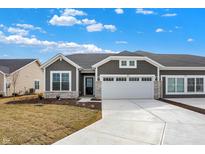 Inviting home with a two-car garage and stone accents on a partially-landscaped lawn at 1603 Clover Crossing Dr # 1A, Greenfield, IN 46140