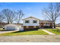 Charming two-story home with a well-maintained lawn, brick accents, detached garage, and inviting curb appeal at 229 W Taylor St, Pendleton, IN 46064