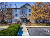 Attractive condo building with blue door, brick facade, and manicured landscaping under a bright sky at 240 Legends Creek # 206, Indianapolis, IN 46229