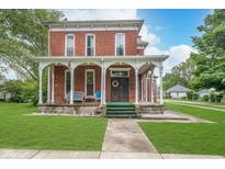 Charming two-story brick home featuring a spacious front porch and well-manicured lawn at 300 S Market St, Thorntown, IN 46071