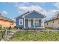 Charming blue home with white trim and covered porch exudes curb appeal and a welcoming entrance at 301 Villa Ave, Indianapolis, IN 46201