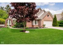 Charming brick home featuring a well-manicured lawn, mature landscaping, and an attached two-car garage at 3034 Tiffany Ct, Carmel, IN 46033
