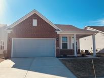 Charming brick and siding home with an attached garage and well-maintained lawn at 4889 Lilium Dr, Plainfield, IN 46168