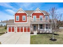 Inviting two-story home featuring red and brick exterior, three-car garage, and charming front porch at 552 Gosford Ct, Westfield, IN 46074