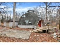 Unique dome home with a deck, red front door, and a detached garage surrounded by trees at 6655 Gopher Dr, Nineveh, IN 46164