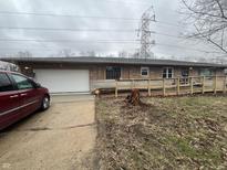 Single-story home featuring a ramp, attached garage, and stone facade at 721 Stover Ave, Indianapolis, IN 46227