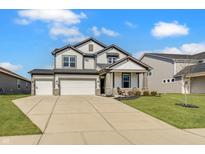 Beautiful two-story home showcasing a three-car garage and well-manicured lawn under a blue sky at 7256 Firestone Rd, Whitestown, IN 46075