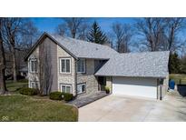 Charming two-story home boasts stone accents, a gray roof, and an attached two-car garage with paved driveway at 9610 Perlinda Ln, Indianapolis, IN 46259