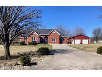 Charming brick home features an attached garage and a detached red garage with a long driveway at 10476 N Prairie Hills Dr, Mooresville, IN 46158
