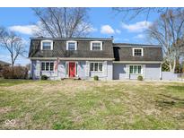Charming home with a red front door, grey brick, shutters, and a well-maintained lawn at 1310 Bowman Dr, Greenfield, IN 46140