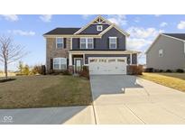 Charming two-story home with stone and siding, a well-manicured lawn, and a two-car garage at 13615 Moorcroft Dr, Fishers, IN 46037