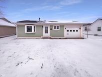 Charming single story home with a light green exterior and a snowy front yard at 1378 South St, Noblesville, IN 46060