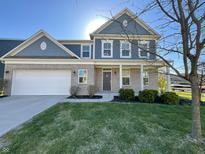 Charming two-story home with a combination brick and blue siding, attached garage, and well-manicured lawn at 15704 Millwood Dr, Noblesville, IN 46060