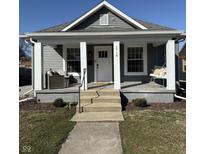 Charming home features a welcoming front porch with swing and seating, enhancing curb appeal at 1718 Gilmore St, Columbus, IN 47201