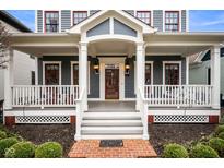 Inviting front porch with a brick walkway and stately columns at 2299 Glebe St, Carmel, IN 46032