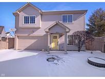 Charming two-story home featuring a yellow front door and attached garage, surrounded by a snow-covered yard at 2365 Grand Fir Dr, Greenwood, IN 46143